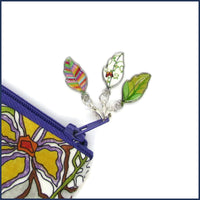 three colourful enamel stitch markers on a project bag zip