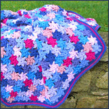 crochet flower blanket on a garden wall