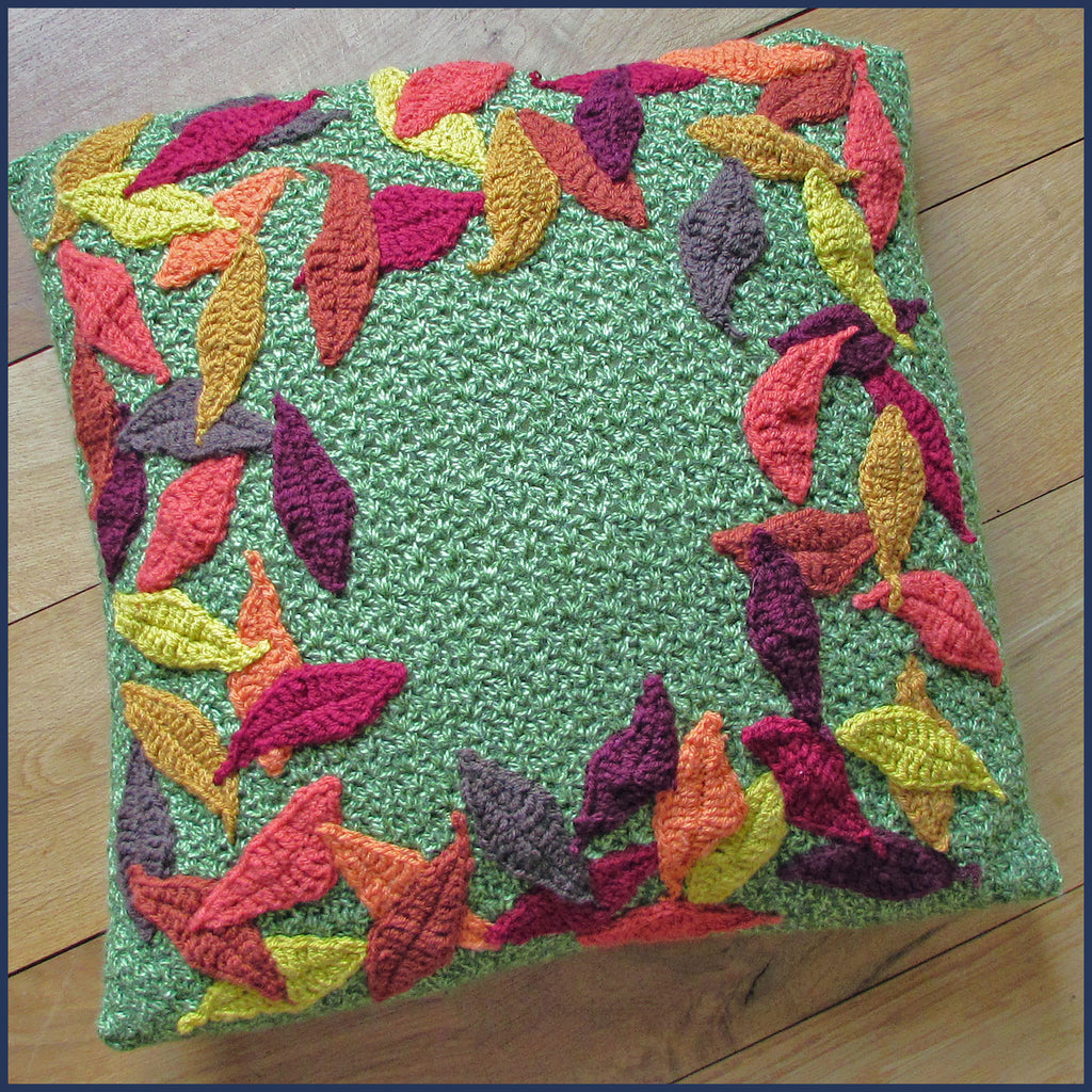 crochet cushion with leaf pattern on a wooden floor