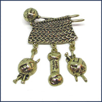 bronze tone badge pin with yarn and sweater knitting