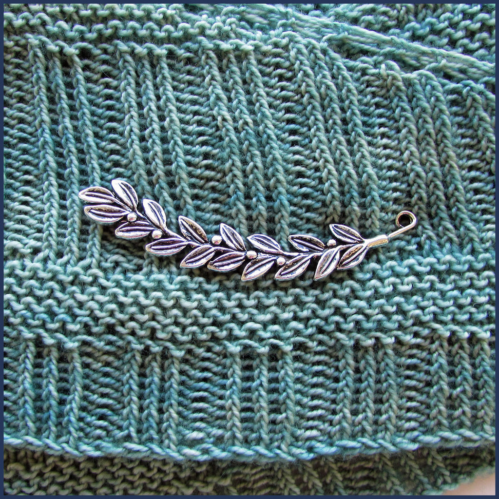 silver leaf and berries shawl pin on knitted fabric
