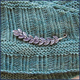 silver leaf and berries shawl pin on knitted fabric