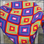 Mexican-inspired crochet blanket draped over a garden chair