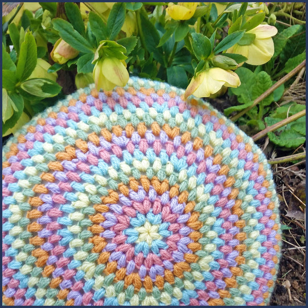 round crochet cushion with hellebores