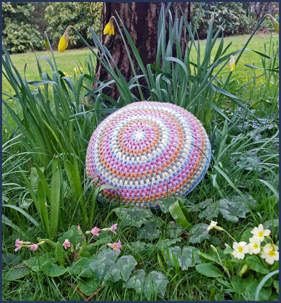 round crochet cushion in a flower border