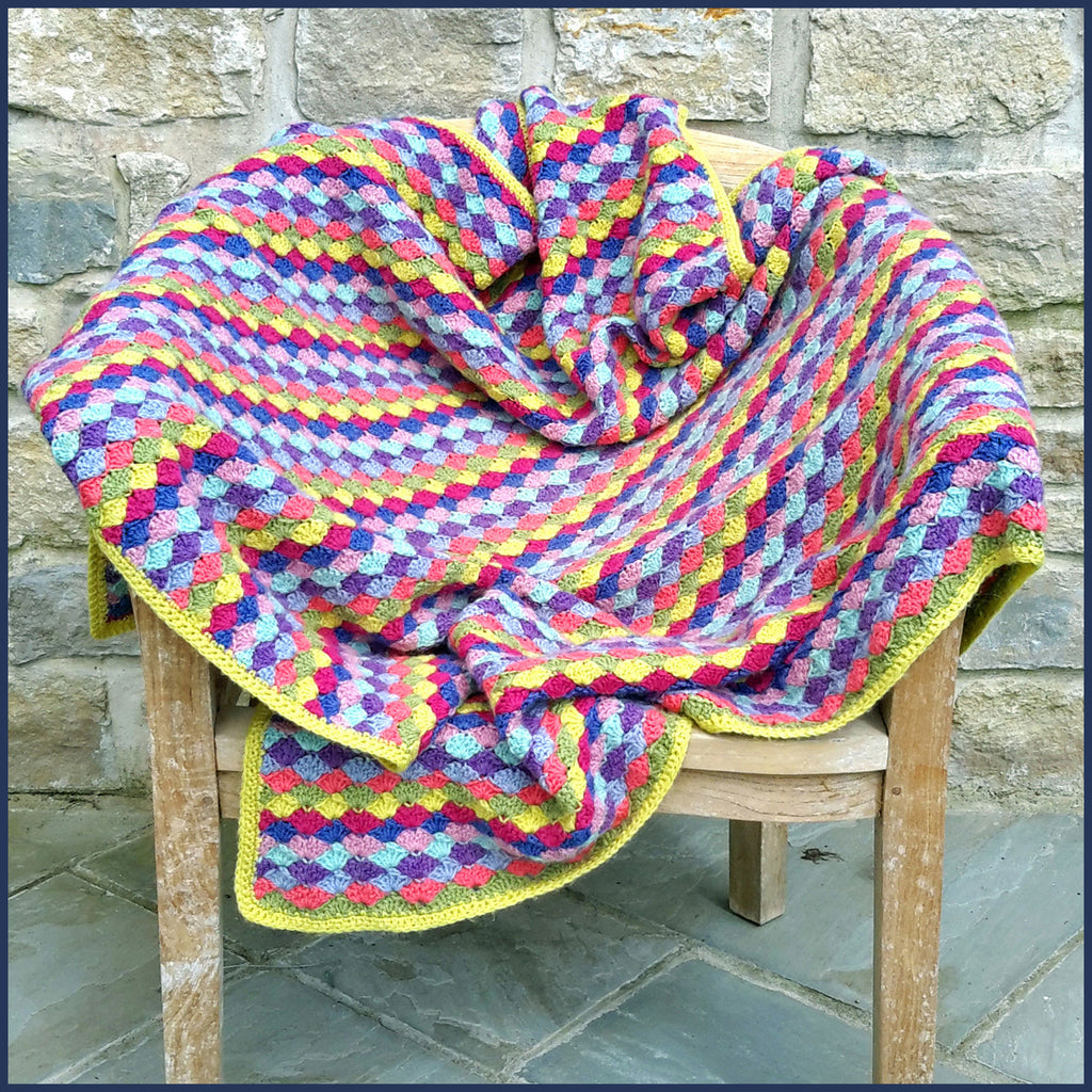 shell stitch crochet blanket on a garden chair