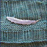 silver feather shawl pin/brooch on knitted fabric