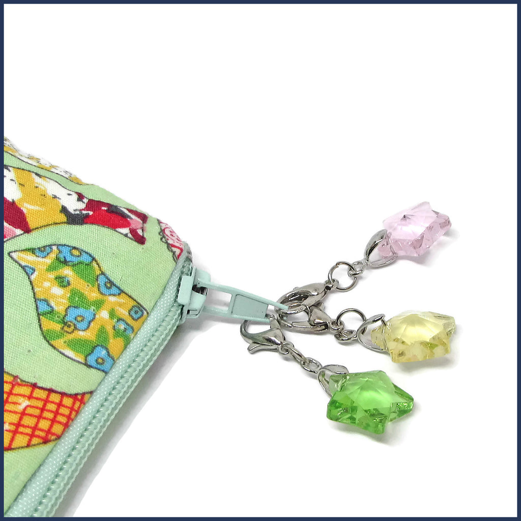 three glass star stitch markers on a project bag zip