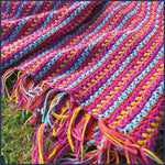 stripey crochet blanket on a lawn